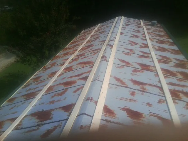 Rusted metal roof panels with new wood purlins before replacement — Storm Damage Roof Repair in Stony Point by Roofing Brothers
