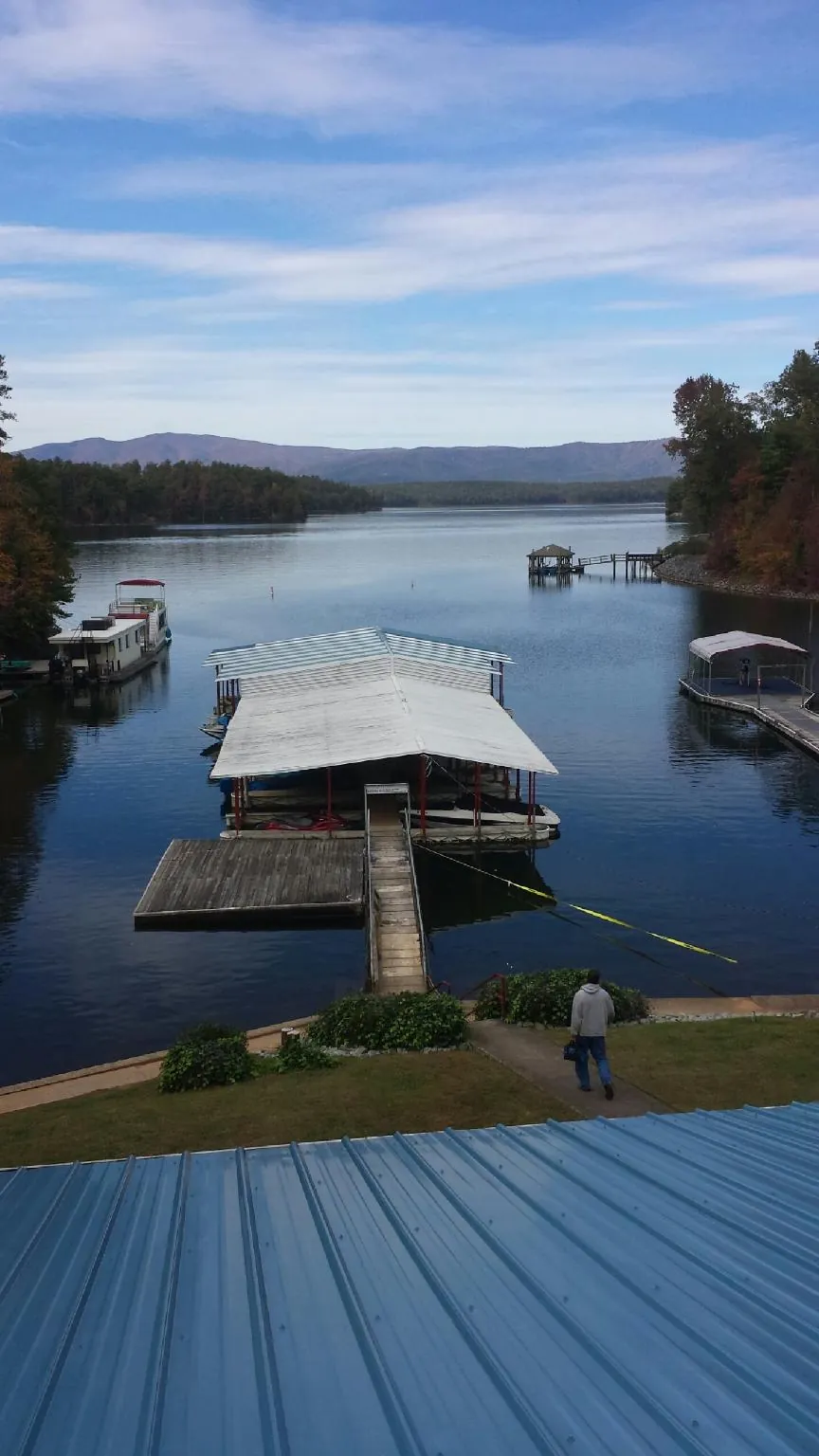 View across a lake from a newly installed blue metal roof in Stony Point